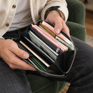 BISON DENIM N8150 – Lange Herren-Geldbörse – ergänzende KI-Kampagnenaufnahme mit einem Mann, der das Produkt hält.